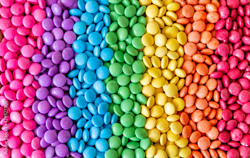 Vibrant sweet rainbow made of multi-colored round candies photo
