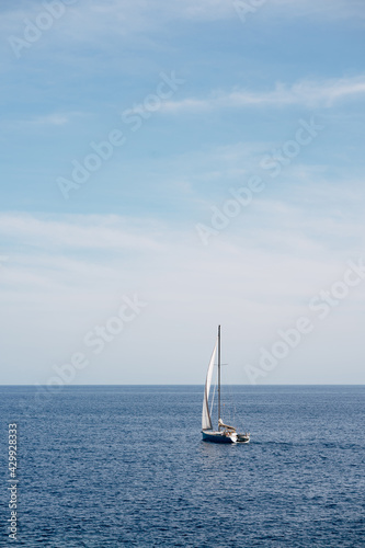 White sailboat floats on the open sea