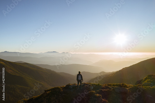 Hiker Man with Backpack on Top of a Mountain