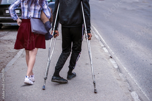 A girl in a mini skirt with a disabled guy on a walk.