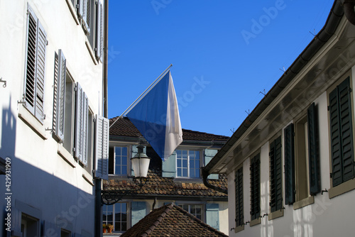 Alley Schipfe at the old town of Zurich with flag of canton and city Zurich. Photo taken April 21st, 2021, Zurich, Switzerland.