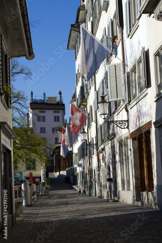 Alley at the old town of Zurich (Schipfe) with Swiss flags in the morning. Photo taken April 21st, 2021, Zurich, Switzerland.