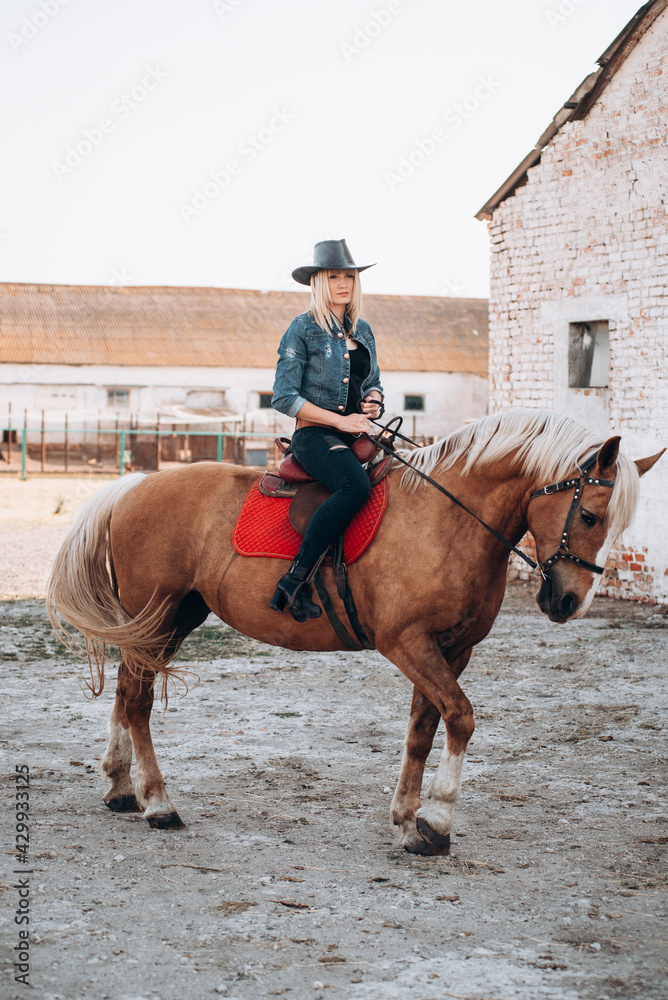 Young woman riding a horse in countryside on rancho