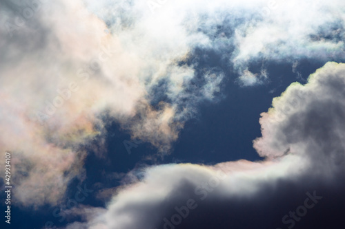White clouds with iridescence against the blue sky