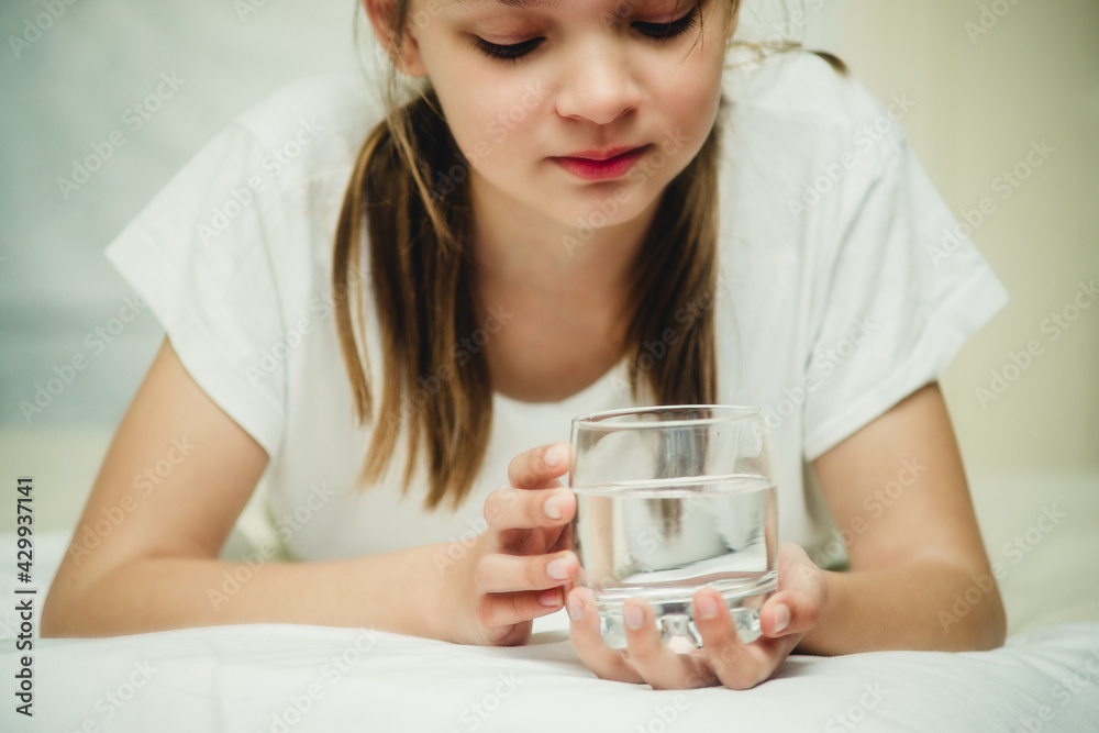 teenage girl with a glass of water on the bed close-up teenage girl with a glass of water on the bed close-up