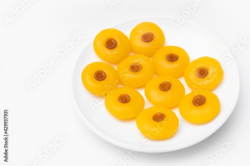 Kanom Sanay Chan, traditional sweet dessert originating in Thailand - Nutmeg –like yellow sweetmeats, serving on white plate isolated on white photo