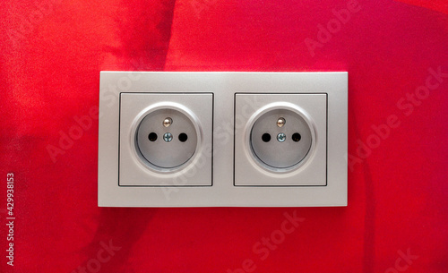 Classic simple european eu double electrical outlet, 220W sockets on the wall, socket object detail, macro, closeup, front view, frontal shot Electricity, power simple concept, red wall, wallpaper photo