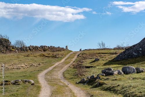 Countryside landscape with road, meadows and stone fences and granite hills in the background. Shot in Sweden, Scandinavia at Säby Kile natural reserve photo