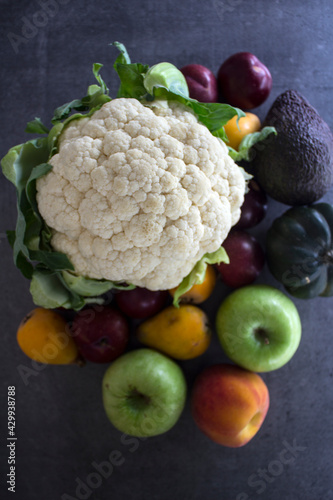 Fototapeta Naklejka Na Ścianę i Meble -  Colorful vegetables and fruits on gray textured background. Top view photo of cauliflower, apples, peach, avocado, plums. Eating fresh concept. 
