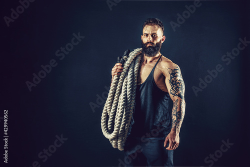Fototapeta Naklejka Na Ścianę i Meble -  Muscular man working out with heavy rope. Photo of man with naked torso. Strength and motivation. 