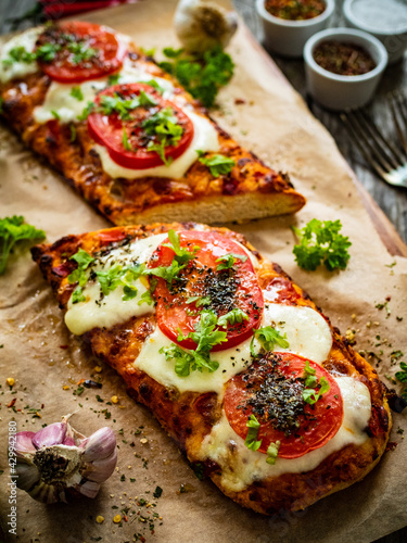 Focaccia - roasted sandwiches with mozzarella and tomatoes on wooden background 