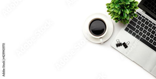 Flat lay, top view office table desk. Workspace with blank Laptop, office supplies, pencil, green leaf, and coffee cup on white background.