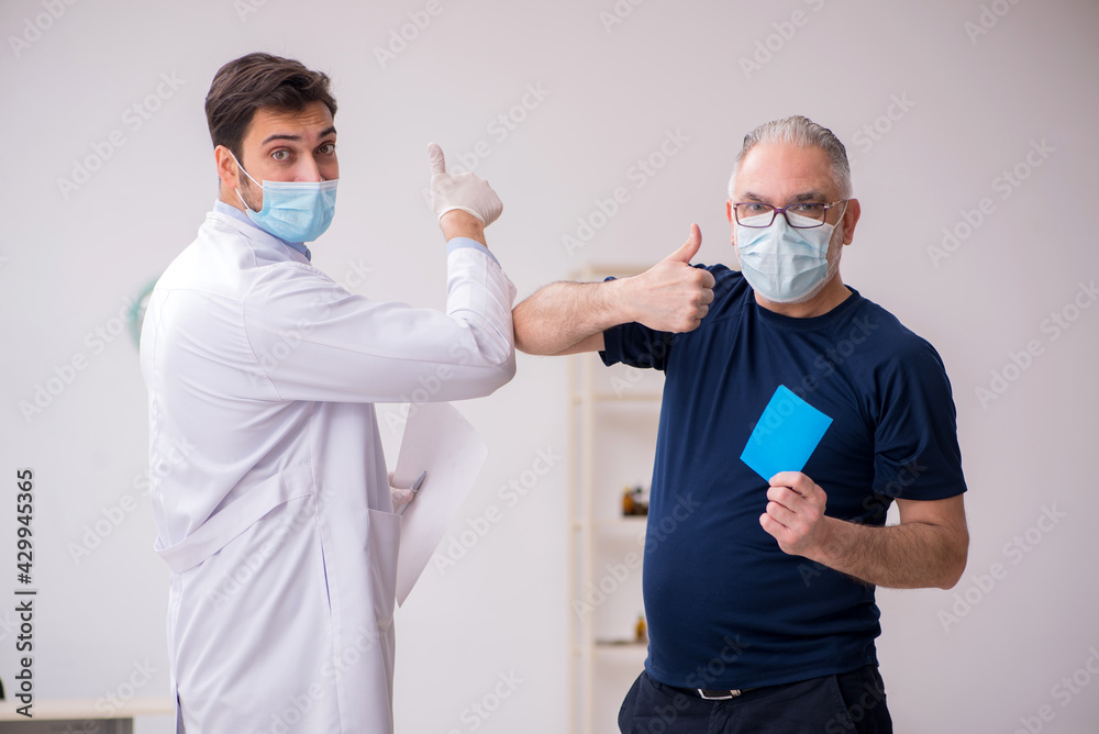 Old male patient visiting young male doctor in vaccination conce Old male patient visiting young male doctor in vaccination conce