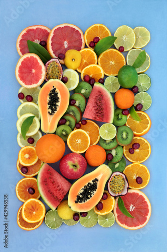Immune boosting summer sunshine fruit collection very high in antioxidants  anthocyanins  lycopene   vitamin c. Natural health care concept. Flat lay on mottled blue background with border.