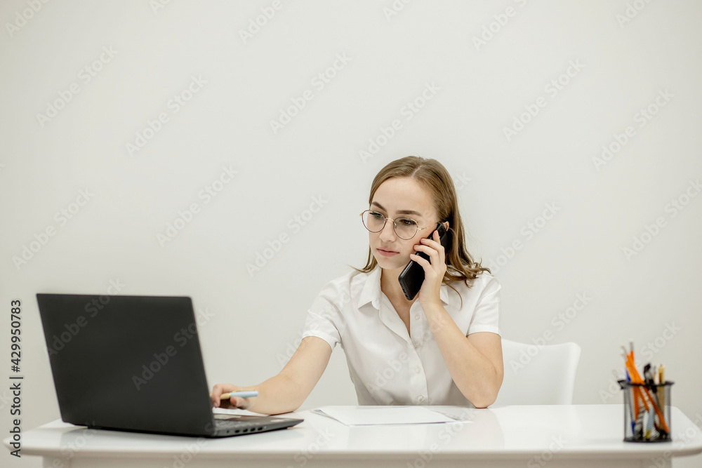 Close-up portrait of a young confident female office manager at her workplace, ready for doing business task. Close-up portrait of a young confident female office manager at her workplace, ready for doing business task.