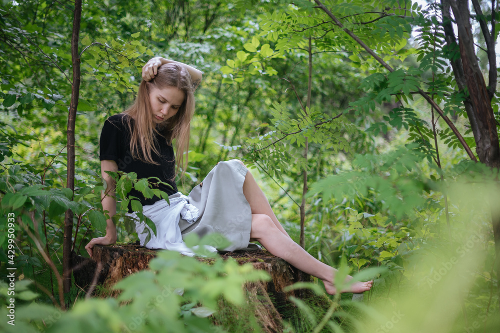 Fototapeta premium Practice of meditation and interaction with nature. Girl in green forest