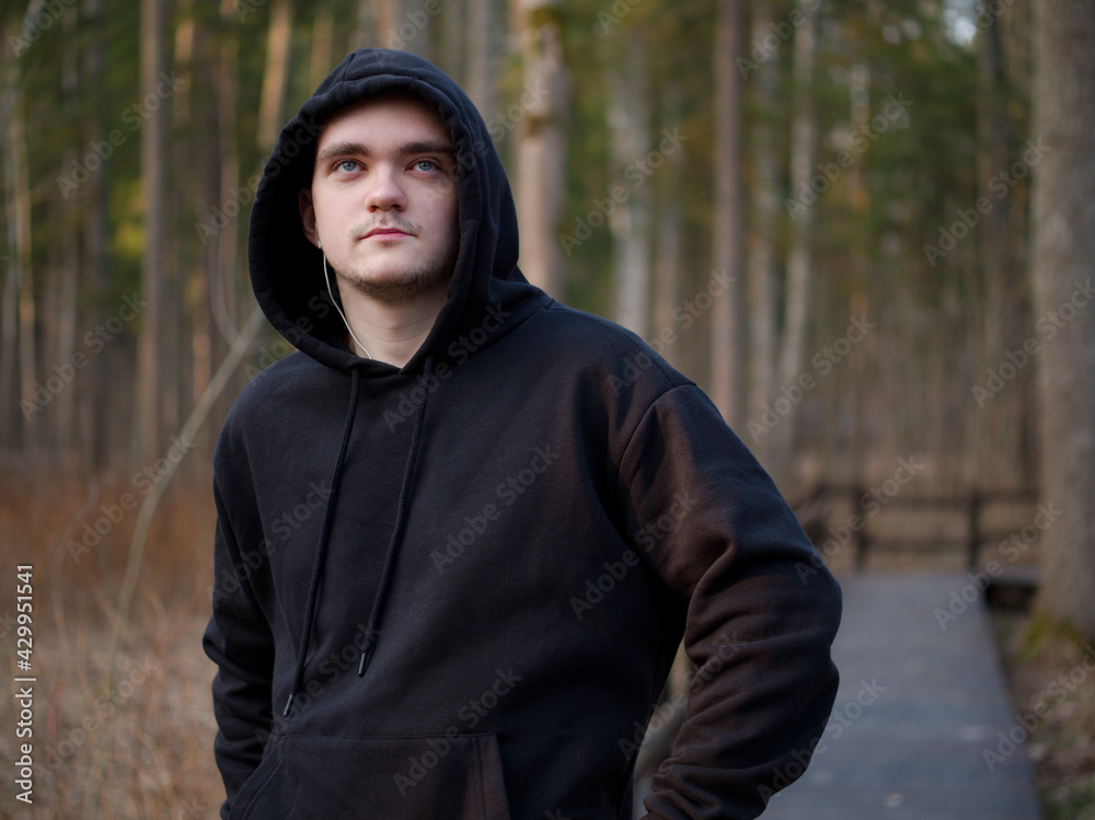 A guy in a black tracksuit, a portrait on a forest background, the sun at sunset, the guy goes in for sports, the concept of a healthy lifestyle A guy in a black tracksuit, a portrait on a forest background, the sun at sunset, the guy goes in for sports, the concept of a healthy lifestyle