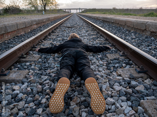 Female lying on the railroad tracks photo