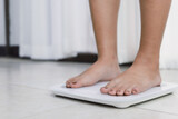 feet standing on electronic scales for weight control. Measurement instrument in kilogram for a diet control.