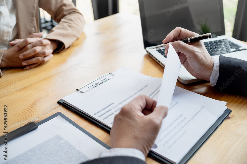 Examiner reading a resume during job interview at office Examiner reading a resume during job interview at office