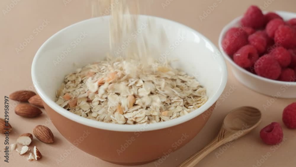 Muesli falling in a bowl in slow motion. Healthy breakfast cereals Oat Muesli with dried fruits Muesli falling in a bowl in slow motion. Healthy breakfast cereals Oat Muesli with dried fruits