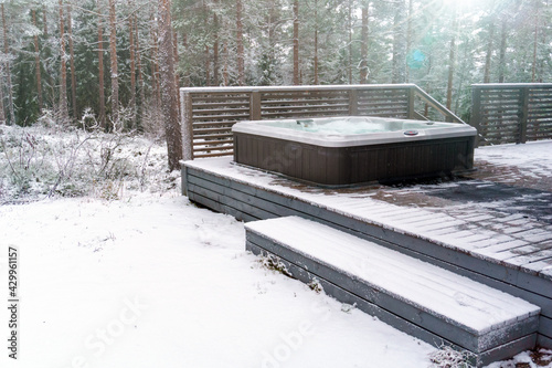 Modern outdoor hot tub on a wooden deck in a cold winter day, Salo, Finland. photo