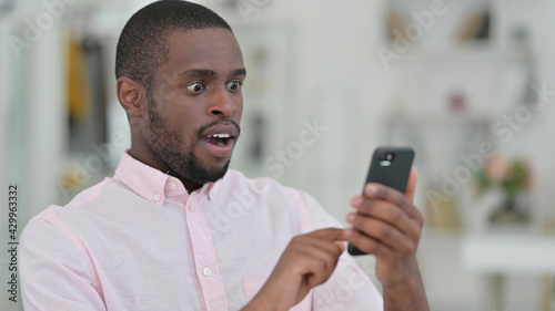 Portrait of African Man Reading to Loss on Smartphone, Failure 