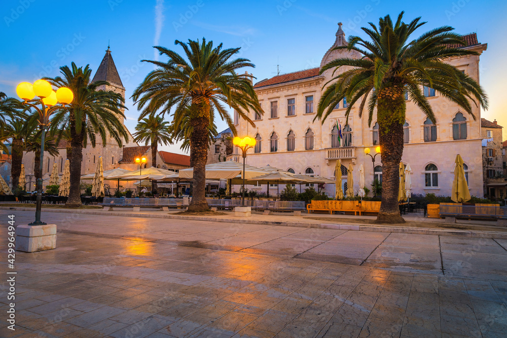 Promenade with street cafes and palm trees at dawn, Trogir