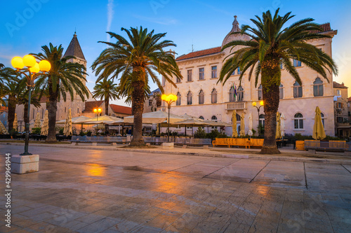 Promenade with street cafes and palm trees at dawn, Trogir