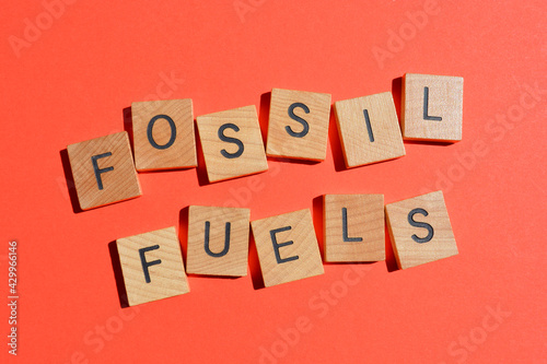 Fossil Fuels, words in wooden alphabet letters isolated on red