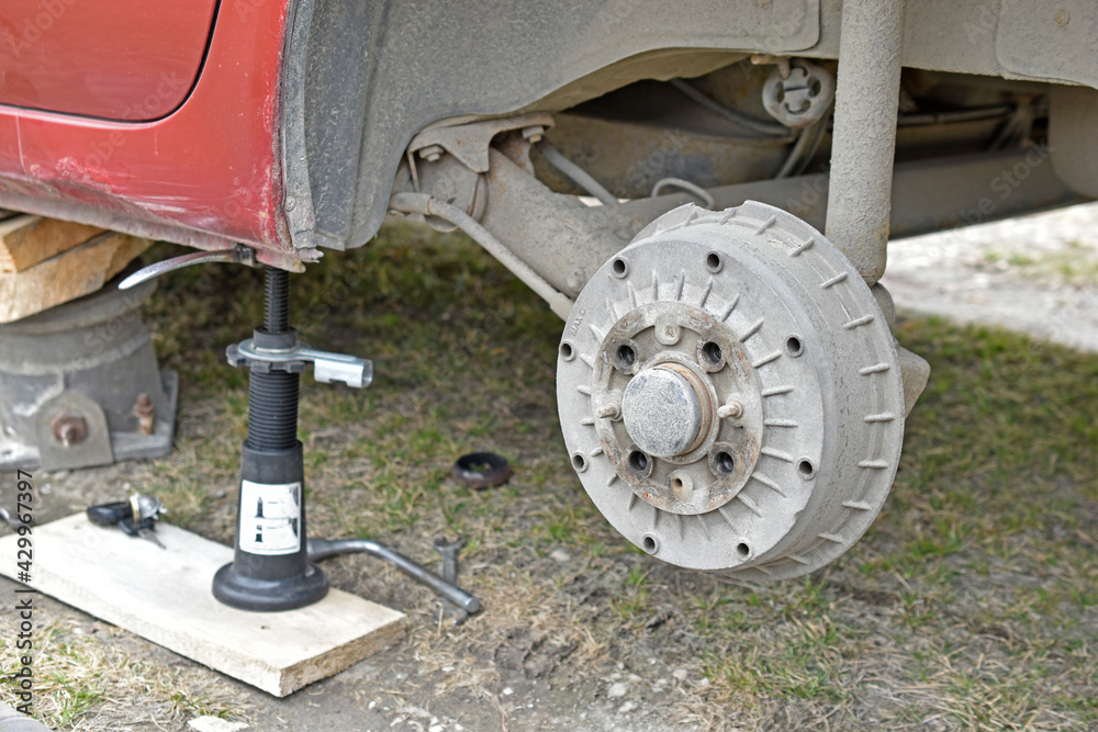 Fototapeta premium Mounting the wheel at the red car