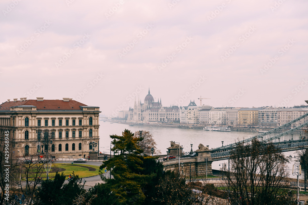Great view of the parliament building, shrouded in haze, in daylight in Budapest