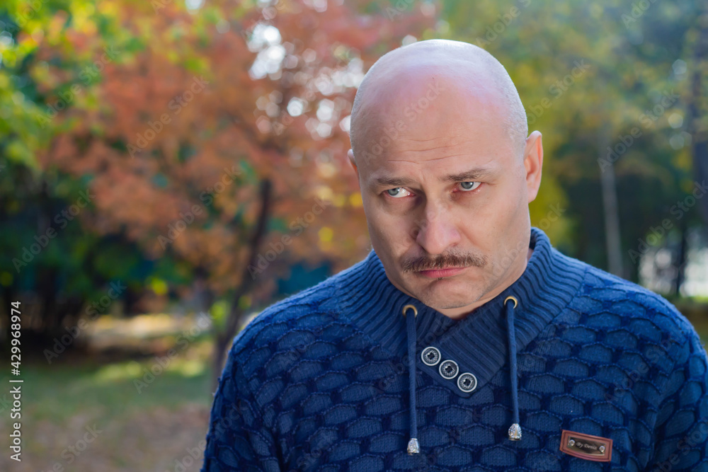 Portrait of a sad bald man in a blue sweater Portrait of a sad bald man in a blue sweater