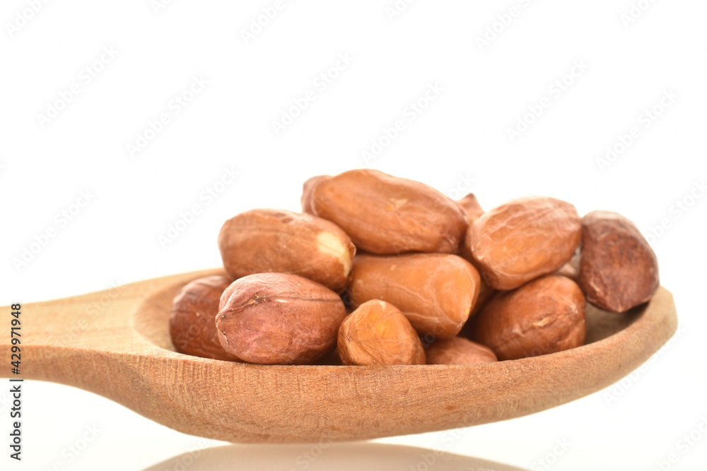 Obraz premium Organic peeled peanuts with a wooden spoon, close-up, isolated on white.