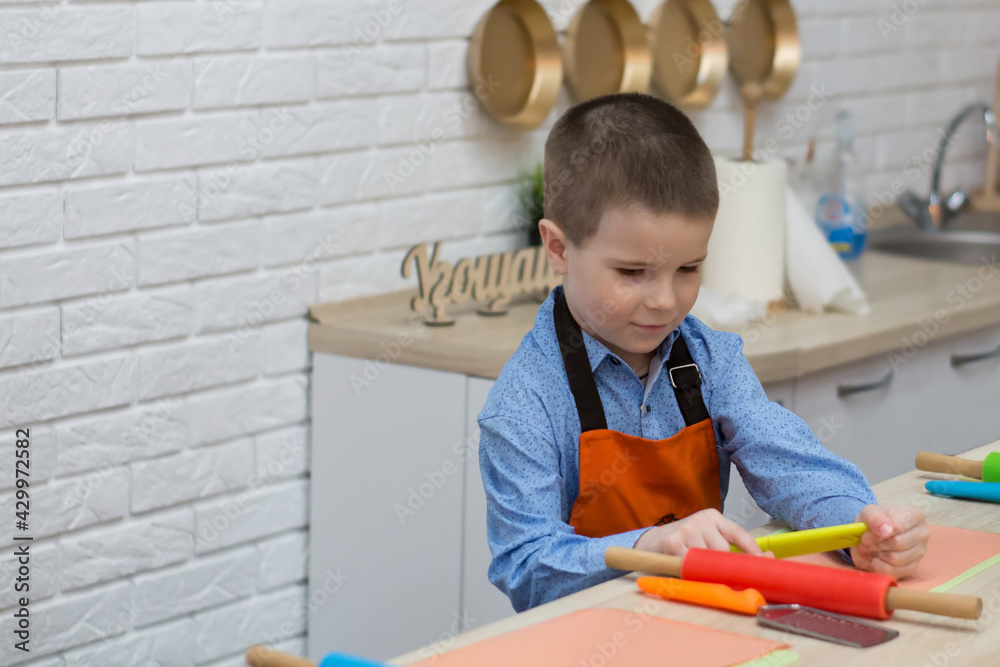 little boy and kitchen utensils, child in a bright kitchen little boy and kitchen utensils, child in a bright kitchen