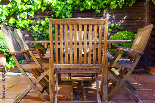 Outdoor wooden garden furniture, chairs and tables to enjoy the good weather.