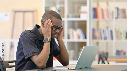African Man Reacting to Loss on Laptop in Library
