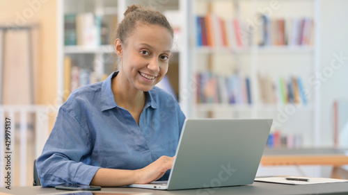 Cheerful African Woman with Laptop Smiling at Camera
