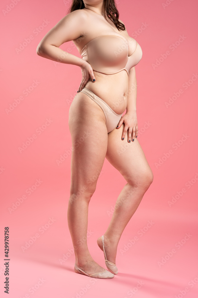 Sexy woman with very large breasts in a push-up bra on pink background,  perfect female body ภาพถ่ายสต็อก