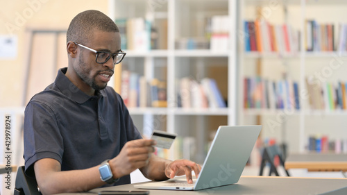 Online Shopping by Young African Man on Laptop in Office
