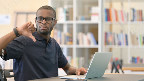 Thumbs Down by Young African Man working in Library