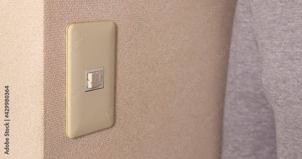 Light switch pushing by male hand daytime closeup