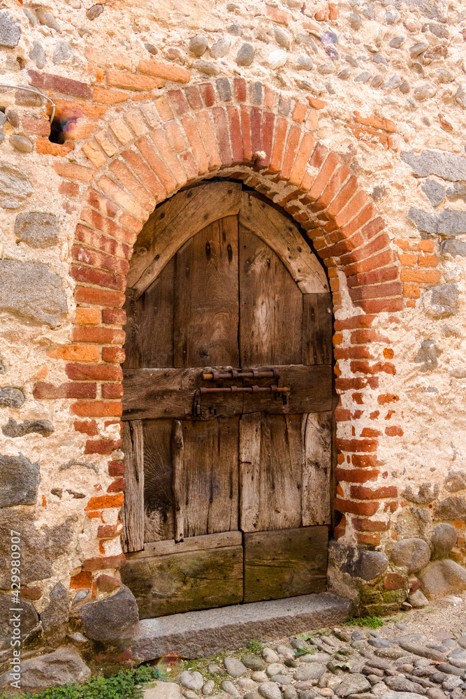 Ricetto di Candelo. Antica porta in legno, con edera rampicante sul muro, in mattoni rossi. Villaggio medievale a Biella, Piemonte, Italia
Ricetto di Candelo. Antica porta in legno, con edera rampicante sul muro, in mattoni rossi. Villaggio medievale a Biella, Piemonte, Italia