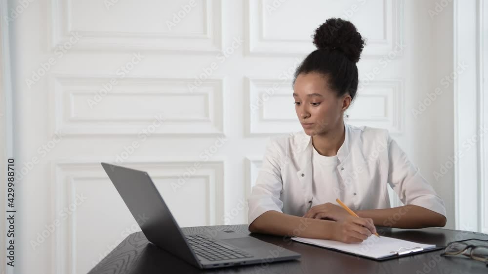 Young businesswoman sitting to table with laptop, write down information with pencil. Beautiful and smart woman freelancer working at home. Concept of manager Young businesswoman sitting to table with laptop, write down information with pencil. Beautiful and smart woman freelancer working at home. Concept of manager