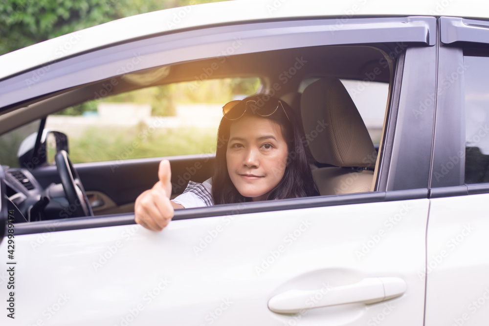 Happy asian woman sitting in the car looking out window,Car insurance concept