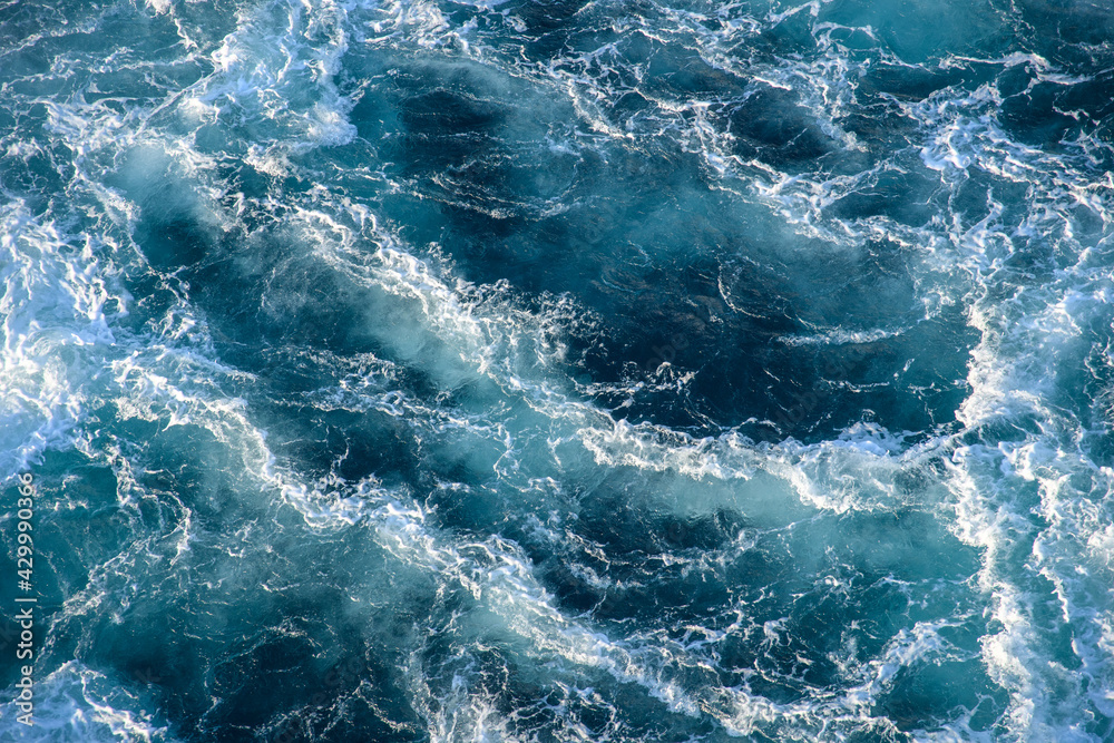 Stormy ocean waves backlit by the light of the setting sun. Transparent. Navy blue. Blue. Background. Pattern. Stormy ocean waves backlit by the light of the setting sun. Transparent. Navy blue. Blue. Background. Pattern.