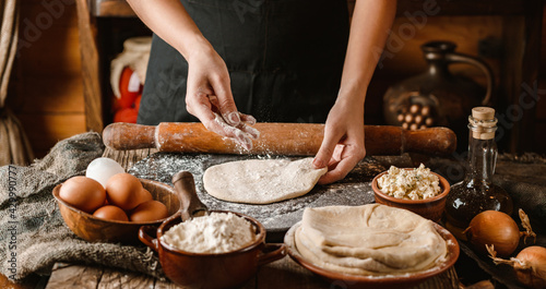 Woman hands cooking bread with cheese, eggs and herb on rustic wooden background. Homemade healthy food concept, toning