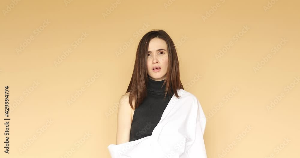 Upset gloomy Caucasian woman looks sadly at camera has sad expression purses lower lip wears turtleneck isolated over beige background complains as hears something disappointing. Upset gloomy Caucasian woman looks sadly at camera has sad expression purses lower lip wears turtleneck isolated over beige background complains as hears something disappointing.