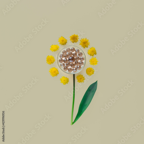 Futuristic flower with glass pearls in the center and with dandelion petals on beige background. photo