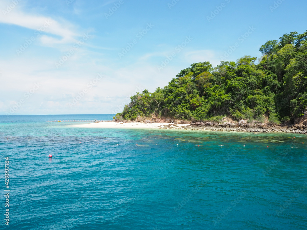 Island in the blue sea with white sky and clouds.